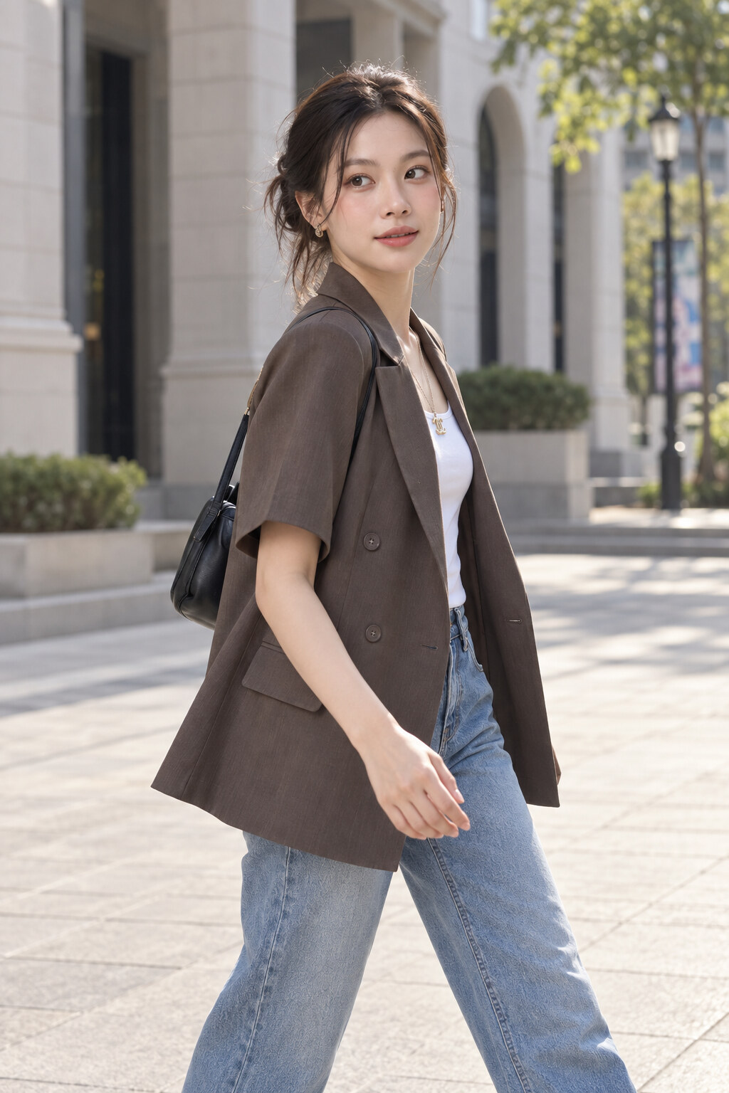 Blazer nâu tay ngắn phối áo thun trắng và quần jean khi đi bộ.