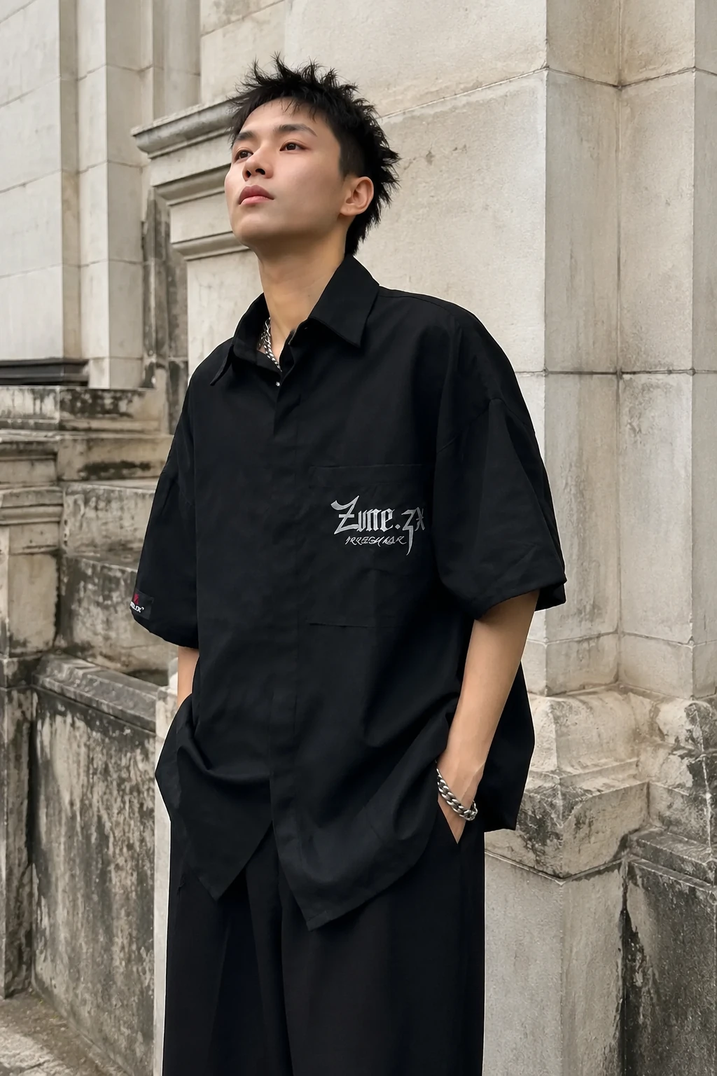 RAW SUEDE SHIRT đen tay ngắn với cổ nhọn và dấu bạc trước ngực