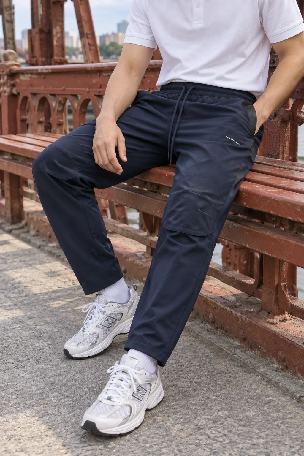 Polo trắng sơ vin nhẹ để lộ dây eo và phần chữ nhỏ trên quần navy.